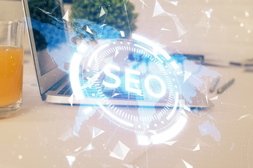 Multi exposure of table with computer and seo drawing hologram. Search optimization concept.