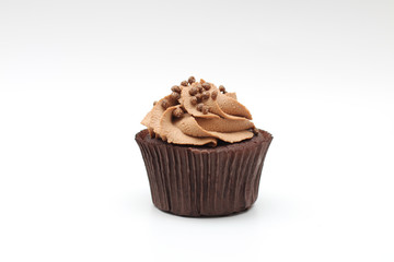 Isolated chocolate cupcake with cream top and crispy topping on a white background