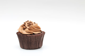 Isolated chocolate cupcake with cream top and crispy topping on a white background