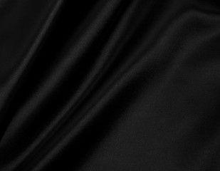 Smooth elegant black silk or satin texture as abstract background. Luxurious background design