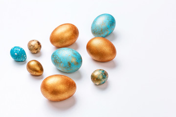 Blue and golden modern easter eggs on a white background. Top view. Isolated.