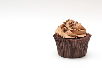 Isolated chocolate cupcake with cream top and crispy topping on a white background
