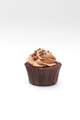 Isolated chocolate cupcake with cream top and crispy topping on a white background
