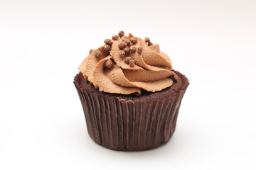 Isolated chocolate cupcake with cream top and crispy topping on a white background