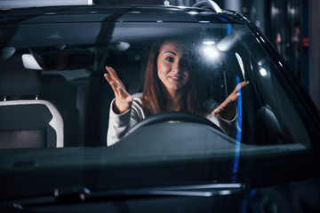 Young woman is inside of brand new modern automobile