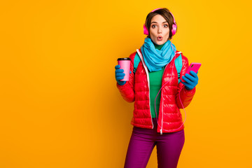 Photo of funny blogger lady open mouth hold telephone listen earphones youth music drink coffee wear casual red coat blue scarf gloves pants isolated yellow color background