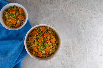 Spelt porridge in a white bowl, light blue napkin background.