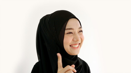 Close Up Portrait of a Young Asian Muslim Woman dressing in the traditional Hijab looking at camera smiling confident on a white background