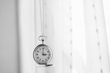 Vintage pocket watch and white drape background