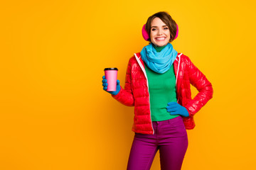 Photo of funny pretty lady holding paper cup hot takeout coffee cold day energy drink wear casual red coat blue scarf gloves ear covers pants isolated yellow color background