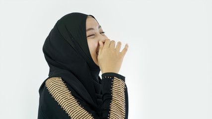 Close Up Portrait of a Young Asian Muslim Woman dressing in the traditional Hijab looking at camera smiling confident on a white background