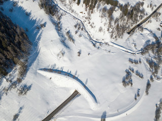 Aerial view of avalanche protection tunnel in Swiss alps. Road underpass in alpine region in...