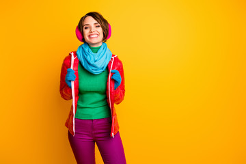 Photo of pretty traveler lady enjoy amazing winter day ready for walk wear stylish casual red overcoat blue scarf gloves pink ear muffs pants isolated yellow color background