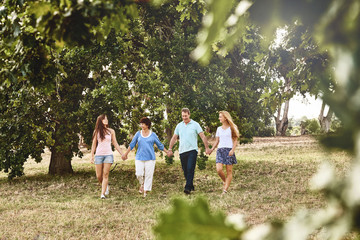 Obraz premium Family of four with adult children walking in a park