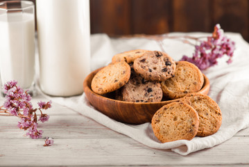 Chocolate chip cookies with milk on burlap and rustic wooden table