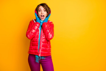 Photo of funny impressed lady enjoy modern earmuffs warmth open mouth wear stylish casual red overcoat blue scarf pink pants isolated yellow color background