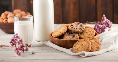 Chocolate chip cookies with milk on burlap and rustic wooden table