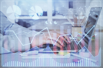 Double exposure of stock market graph with man working on laptop on background. Concept of financial analysis.