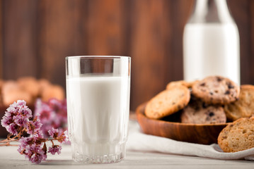 Chocolate chip cookies with milk on burlap and rustic wooden table