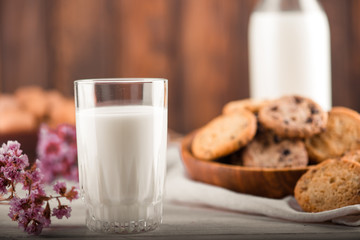 Chocolate chip cookies with milk on burlap and rustic wooden table
