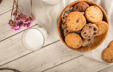 Chocolate chip cookies with milk on burlap and rustic wooden table
