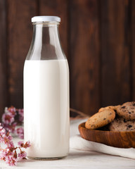 Chocolate chip cookies with milk on burlap and rustic wooden table