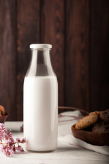 Chocolate chip cookies with milk on burlap and rustic wooden table
