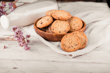 Chocolate chip cookies with milk on burlap and rustic wooden table