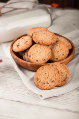 Chocolate chip cookies with milk on burlap and rustic wooden table