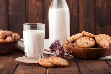 Chocolate chip cookies with milk on burlap and rustic wooden table