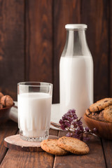 Chocolate chip cookies with milk on burlap and rustic wooden table