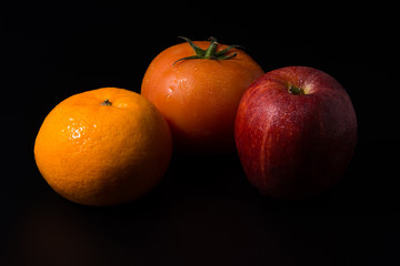 Three fresh fruits isolated on a black background