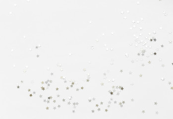 Silver confetti and stars and sparkles on a light background. Top view, flat lay. Copy text. holiday background. For Christmas, New Year, Valentine's Day