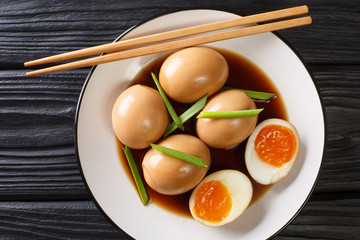 Nitamago is a boiled egg in savory sauce close-up in a plate. Horizontal top view