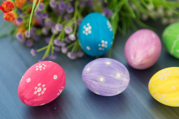 Obraz na płótnie Canvas Easter eggs decoration with and flowers on gray wooden table.