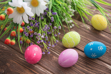 Fototapeta na wymiar Easter eggs and flowers on rustic wooden planks