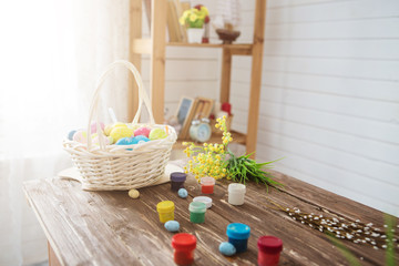 Colorful easter eggs and brushes on wooden table
