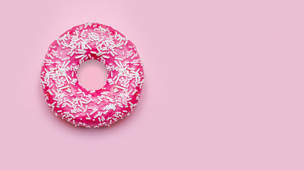 Donuts with icing on pastel pink background.