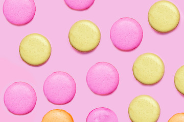 Seamless pattern made of macaroons on the pink background. Flat lay. Food concept.