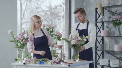 floristry, young successful professional florists collect beautiful bouquet of fresh flowers, give five smiles and look at the camera, business success