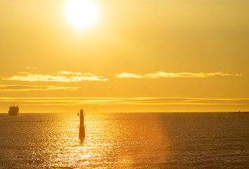 Lighthouse in the strait between the islands of the Stockholm archipelago, lit by the rays of the sun, in the early morning.