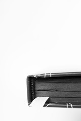Close-up diary with black paper sheets and white bookmark on white background with copy space, vertical. Isolated