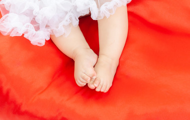 Small legs of baby at the red puff.