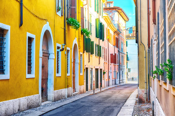 Old town cozy narrow street view with colorful houses in Verona, Italy during sunny day. - Powered by Adobe