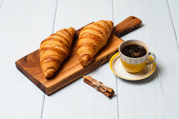 Croissants and coffee on light background. Concept delicious breakfast or lunch