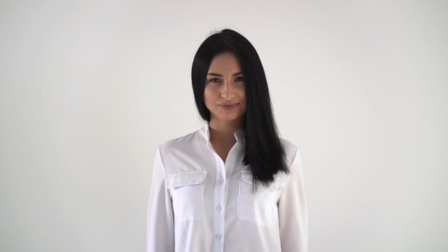 Shooting a portrait of a girl. Young brunette in white blouse laughing