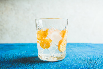 Old fahioned beverage with strong alcohol and kumquats on rustic background. Selective focus. Shallow depth of field.