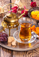 various dried fruits and  Turkish tea in Armudu glass on wooden table.