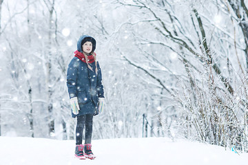 Fototapeta na wymiar smiling happy child in winter / healthy cheerful girl in warm clothes at a frosty winter walk. Snow portrait of a child. Concept of health, happiness, family
