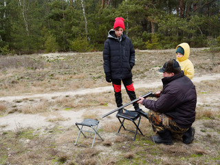 Man teaches children shooting with hunting rifle